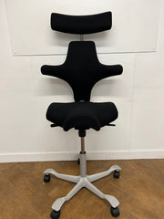 Used HAG Capisco 8107 Saddle Chair in Black Cloth with Headrest and Silver Base.