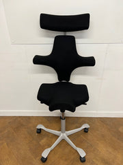 Used HAG Capisco 8107 Saddle Chair in Black Cloth with Headrest and Silver Base.