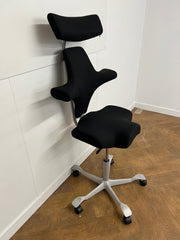 Used HAG Capisco 8107 Saddle Chair in Black Cloth with Headrest and Silver Base.