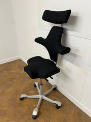 Used HAG Capisco 8107 Saddle Chair in Black Cloth with Headrest and Silver Base.